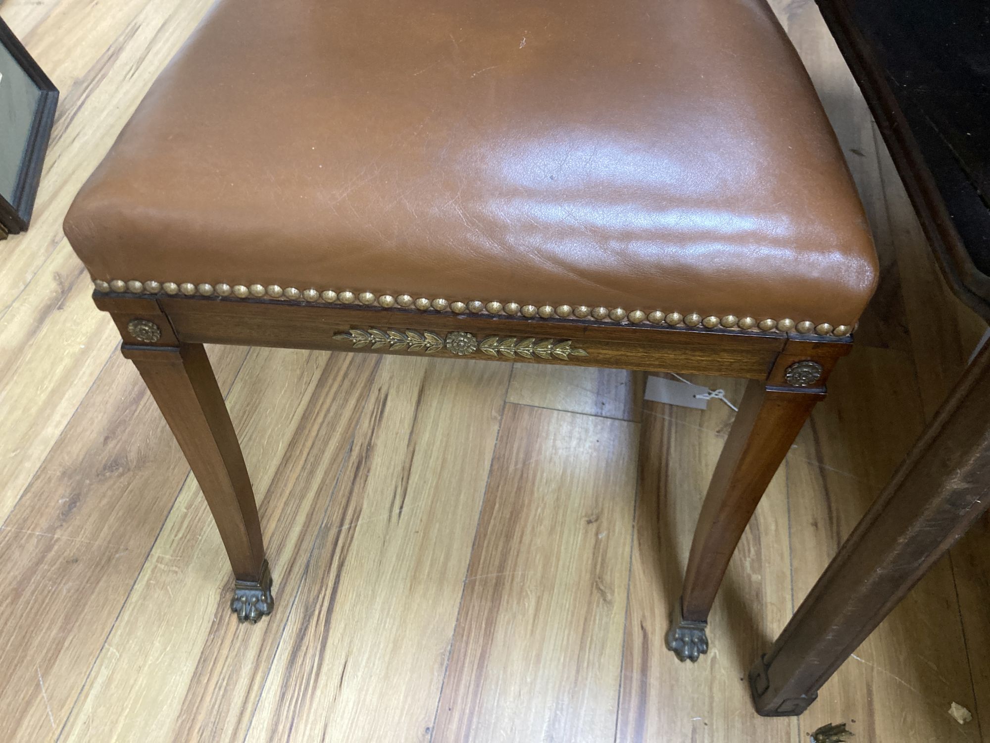 A set of six Empire style brass mounted mahogany dining chairs with tan leather upholstery